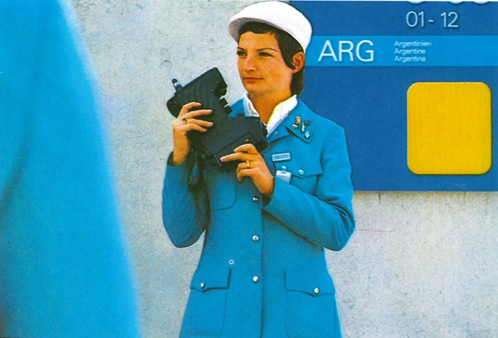 Fotografie einer Frau in blauer Uniform und einem großen Funkgerät