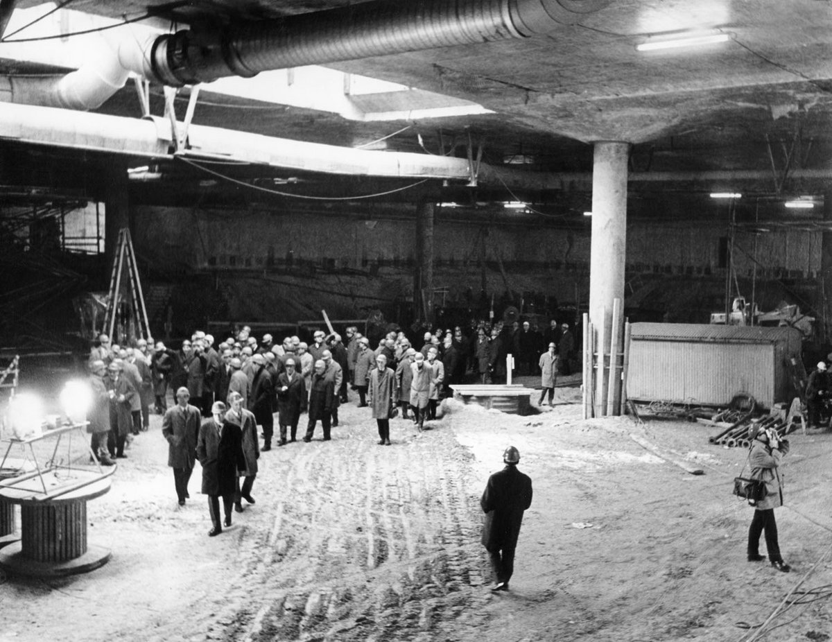 Schwarz-Weiß-Fotografie eines Bautunnels mit einer Gruppe von Menschen