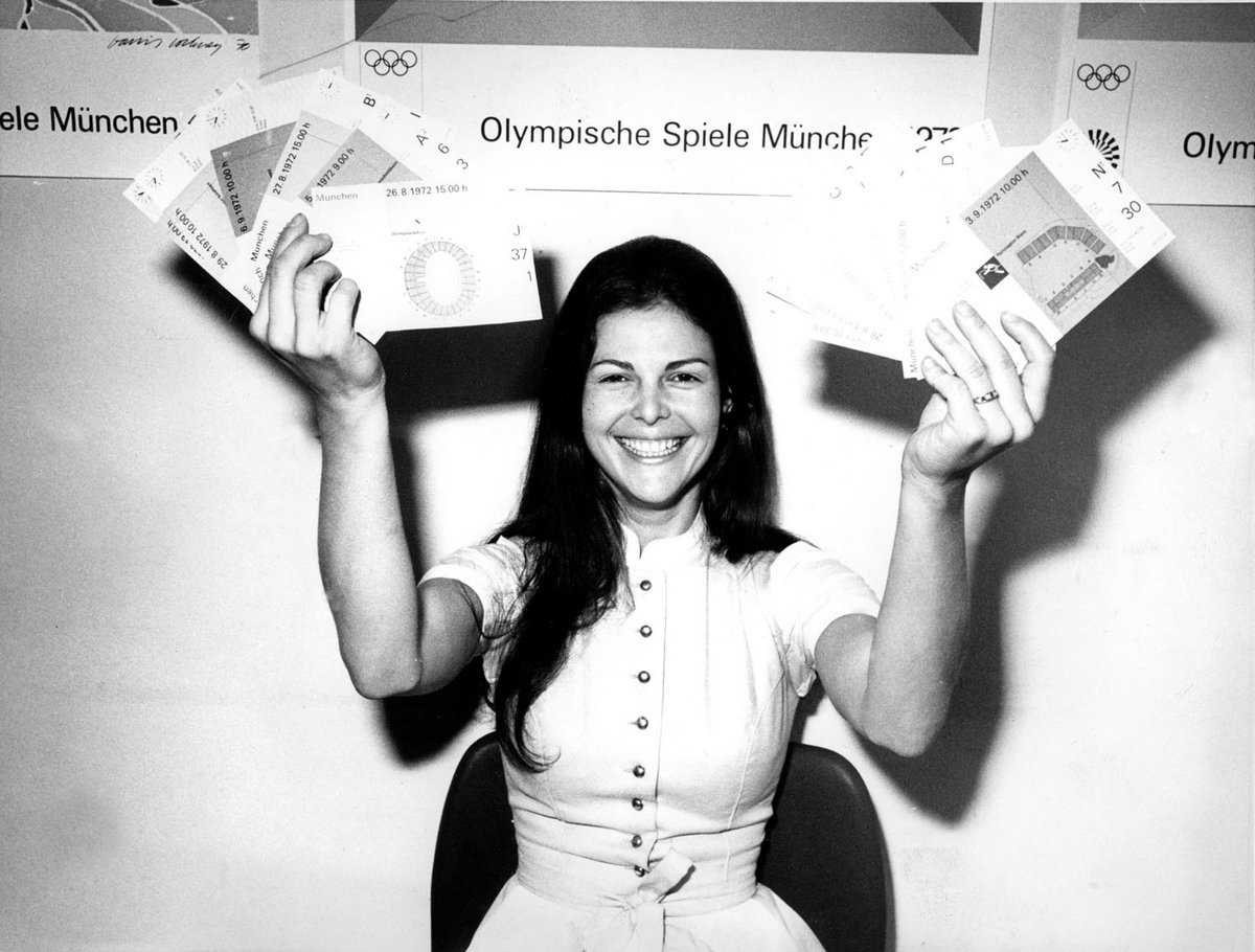 Schwarz-Weiß-Fotografie einer Frau, die Eintrittskarten präsentiert. 