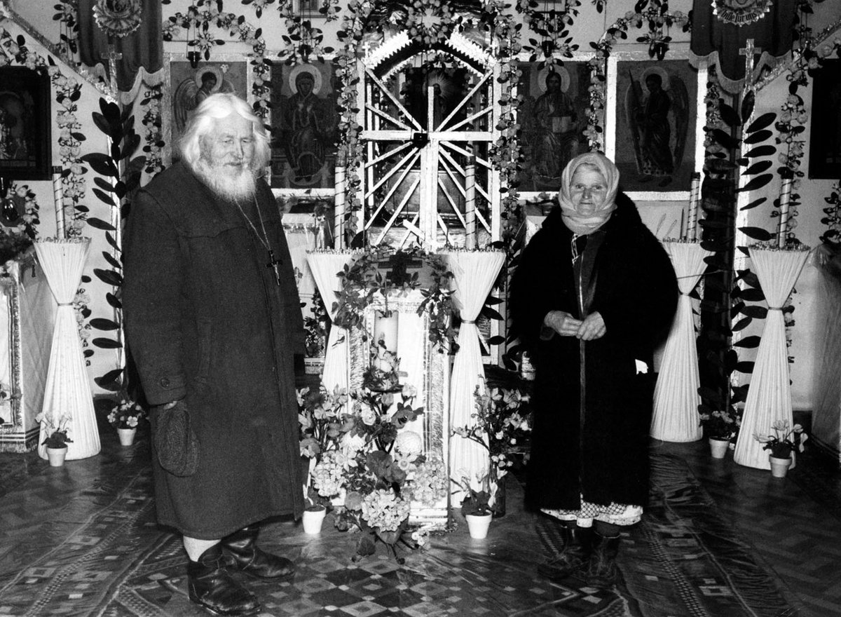 Schwarz-Weiß-Fotografie eines Paares, die in einer Kirche stehen.
