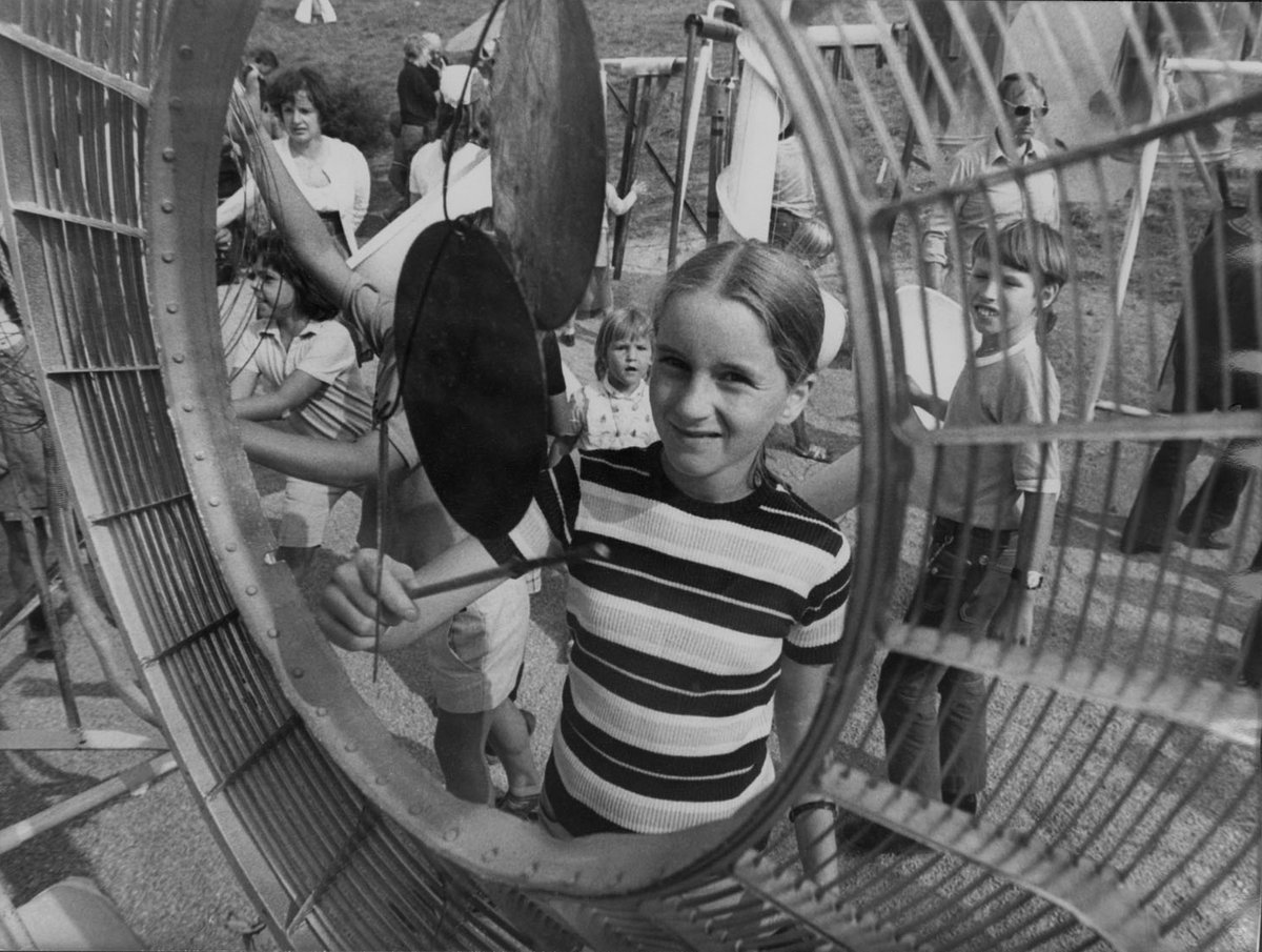 Schwarz-Weiß-Fotografie eines Mädchens das vor einem Musikinstrument steht