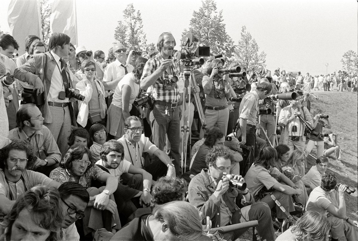 Schwarz-Weiß-Fotografie einer Menschenmenge mit verschiedenster Kameraausrüstung.