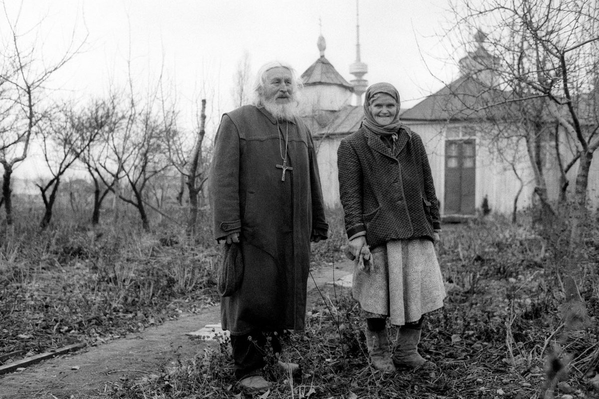 Schwarz-Weiß-Fotografie eines älteren Paares auf einer Wiese 