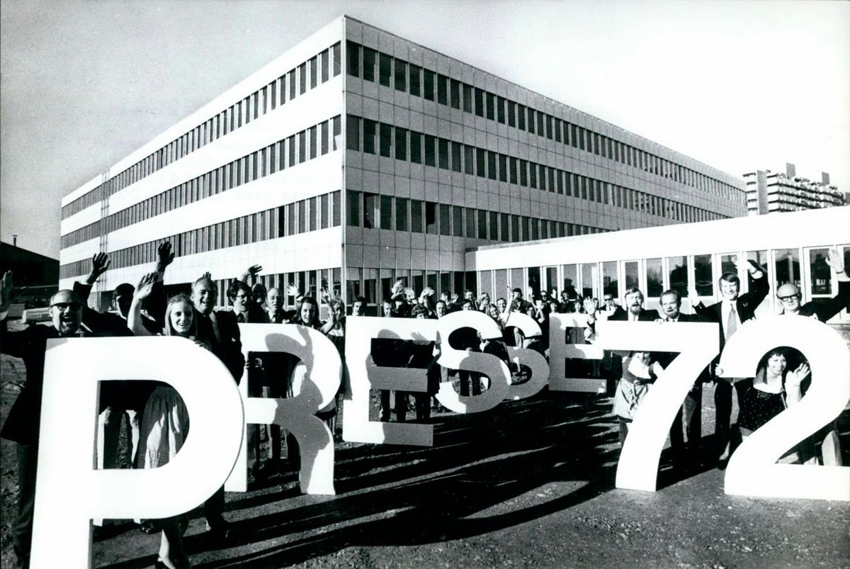 Schwarz-Weiß-Fotografie einer Menschenmenge die "Presse 72“ aus fast mannshohen Buchstaben in die Kamera halten. 