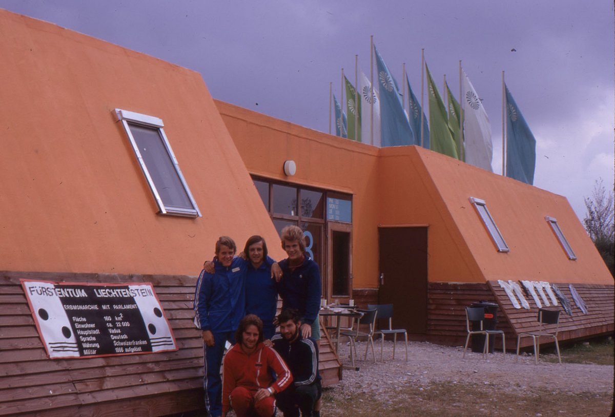 Fotografie einer Jungendgruppe vor einem orangen Haus.