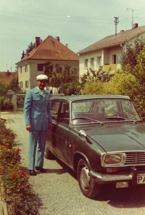 Fotografie eine Mannes in blauer Uniform neben einem Auto
