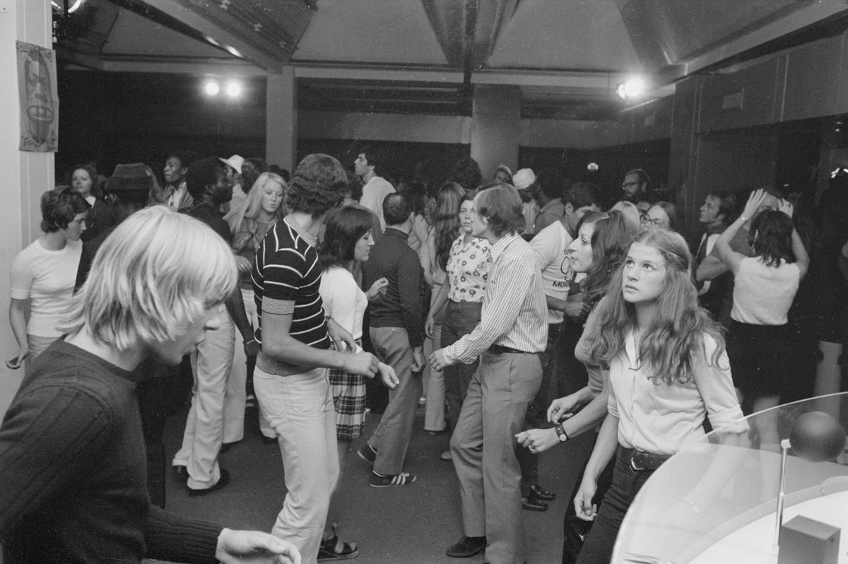 Schwarz-Weiß-Fotografie einer tanzenden Menschenmenge in einer Diskothek