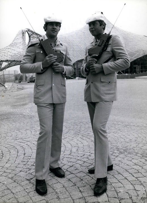 Schwarz-Weiß-Fotografie von zwei Männern in Uniform mit großen Funkgeräten