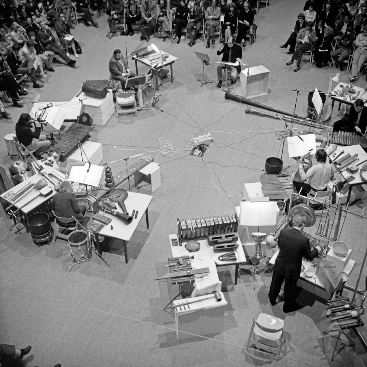 Schwarz-Weiß-Fotografie einer Gruppe Musiker, die Instrumente spielen aus der Vogelperspektive.