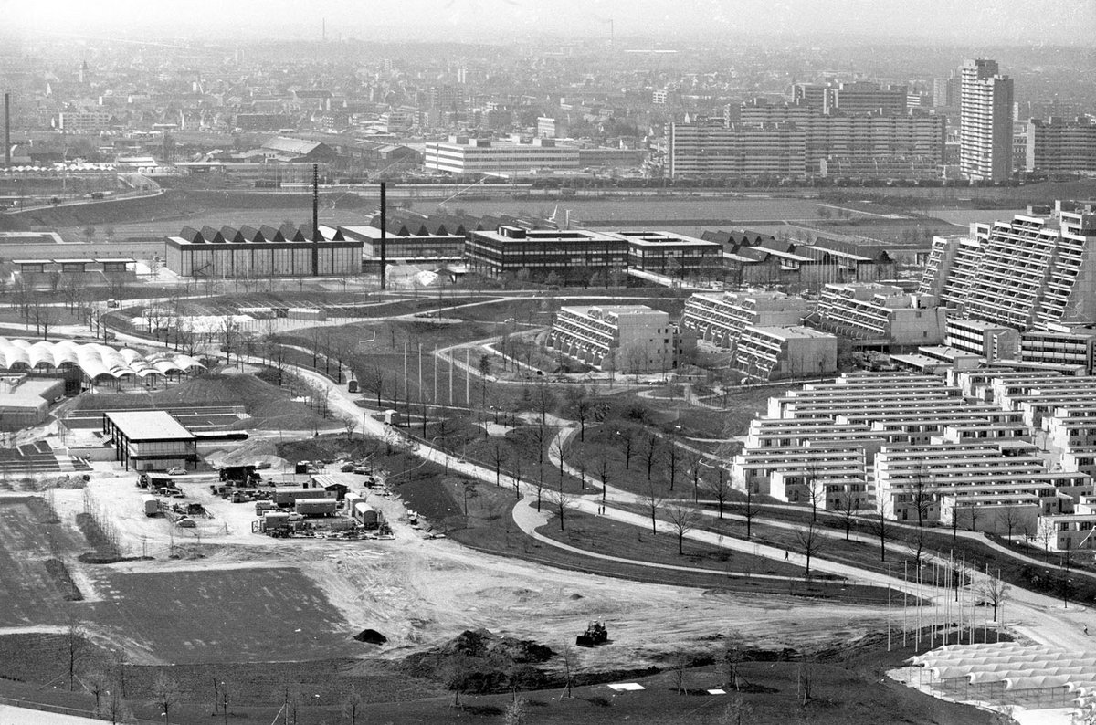 Schwarz-Weiß-Fotografie mehrerer Gebäude und einer Baustelle.