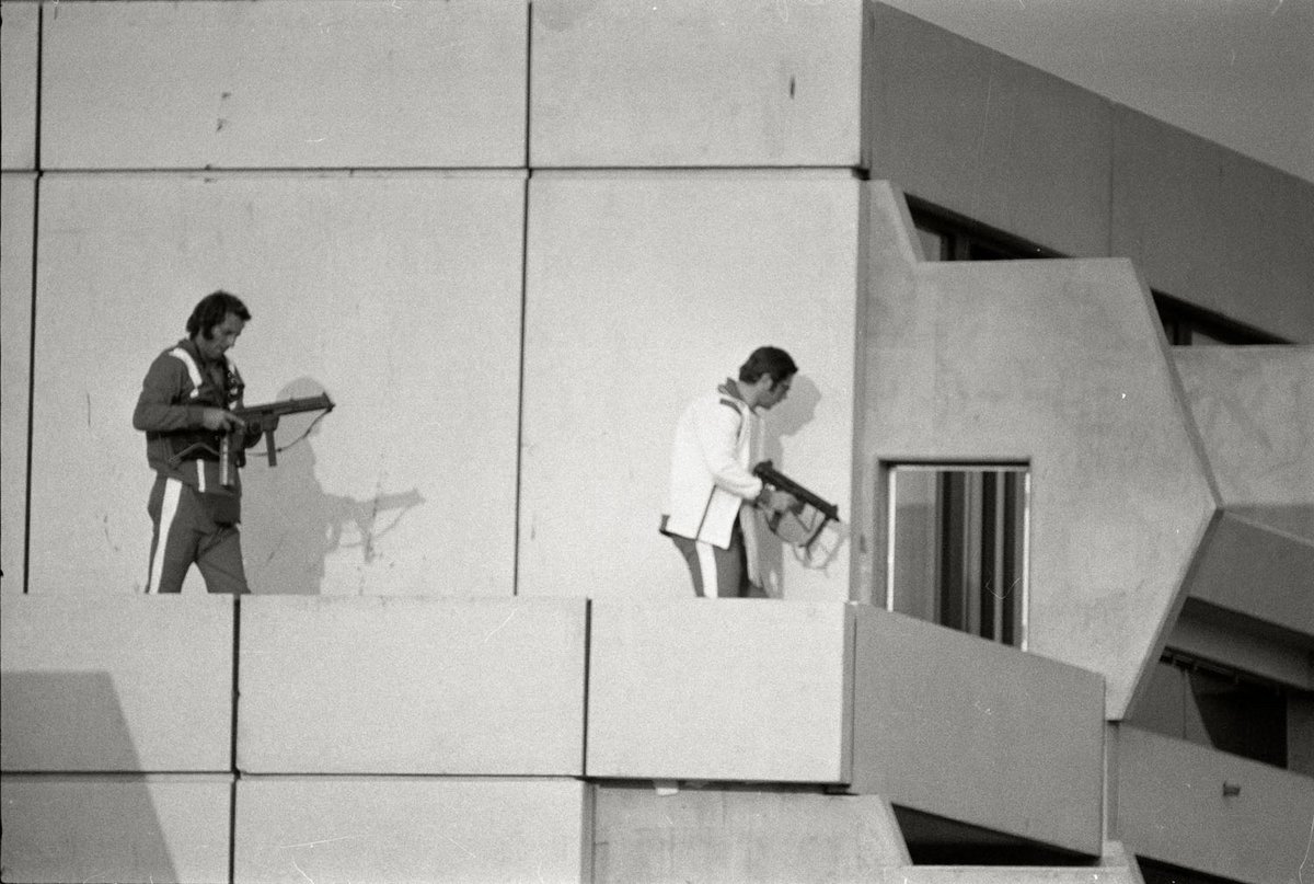 Schwarz-Weiß-Fotografie von zwei Männern die jeweils eine Waffe in der Hand halten.